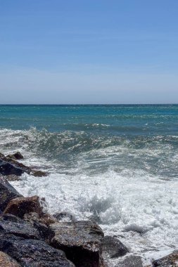 İspanya, Almunecar 'da fırtınalı turkuaz dalgalar altında, dramatik gökyüzü ve güçlü sörfler altında dinleniyor..