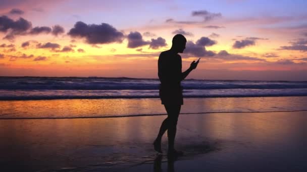 Silueta Del Hombre Caminando Largo Playa Contra Puesta Sol Colores — Vídeos de Stock