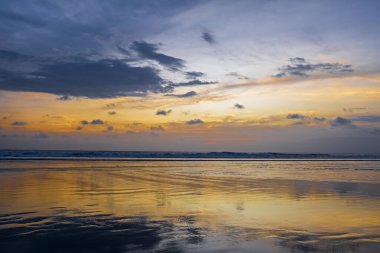 Sonsuz ufku olan inanılmaz sahil günbatımı. Gün batımında gökyüzü ve bulutların arasında güneş olan sakin bir deniz. Meditasyon okyanusu ve gökyüzü arka planı. Huzurlu deniz manzarası. Suyun üzerinde ufuk..