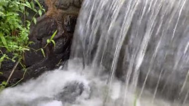 Fresh cold water flowing through canal to Rice Farms. Soil moistening system, Bali, Indonesia. Flowing water in waterway of irrigation system for rice agriculture field.