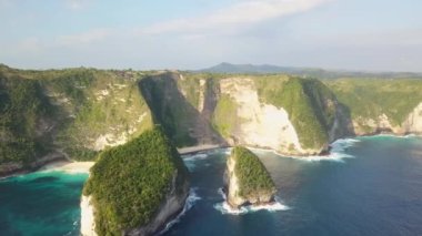 Uçurumun üzerinde Nusa Penida, Endonezya, 4k. Sahil şeridi yeşil ağaçlarının insansız hava aracı görüntüsü. Denizle olan uçurum sınırı. Hint Okyanusu. Dalgalar uçuruma çarpıyor. Kelingking Sahili.