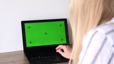 Eğitim, çevrimiçi okul ve uzak öğrenim konsepti - dizüstü bilgisayarında yeşil ekranı olan ve evinde hareket takip işaretleri ve not defteri olan öğrenci kadın..