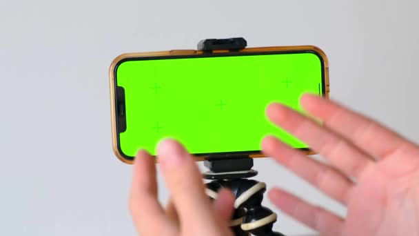 在绿色屏幕手机上 用动作跟踪标记对手部进行特写 智能手机安装在三脚架上 靠在白墙上 Webinar 在线培训 — 图库视频影像