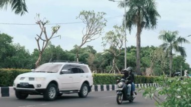 The carriageway of the road. View of a busy road with cars and motorcycles. Driving on the left in Asia. Real time, 4k. Bali, Indonesia, September 5, 2022
