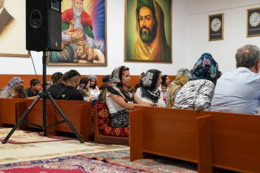 Ankara, Turkey-August 25, 2024:  Alevi people at the cemevi and the picture of caliph Ali at the background. clipart