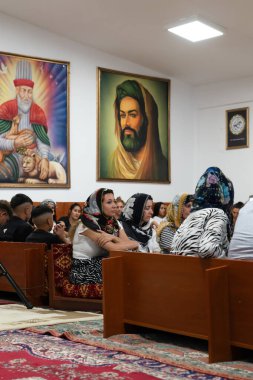 Ankara, Türkiye-25 Ağustos 2024: Alevi kadınlarının mezarlıktaki vejetaryen görüşü ve arka planda halife Ali 'nin resmi.