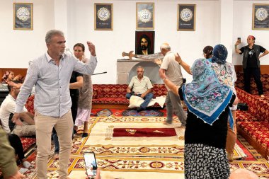 Ankara, Türkiye-25 Ağustos 2024: Alevi halkının ibadethanesi olan Cemevi 'nde yapılan Semah törenine bir göz atın. Semah 'ı yöneten dede, insanlar arasında semah yaparken görülüyor..