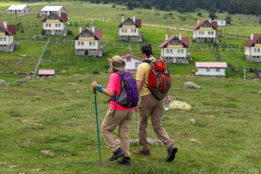 Arka planda yürüyüşteki çift ve Kasimlar Platosu Evleri, Kizilcahamam, Ankara, Türkiye