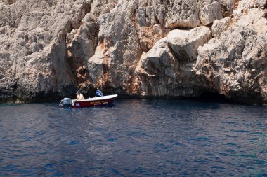Kastellorizo Adası, Dodekanisos, Yunanistan - 6 Ağustos 2024: Mavi mağara tur botu mağaranın hemen önünde