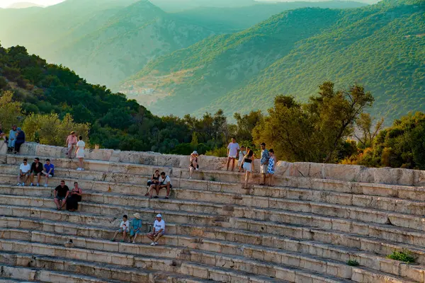 Kas, Antalya, Türkiye - 6 Ağustos 2024: Antik Antiphellos kenti turistlerle birlikte gün batımında bir konser dinlemek üzere toplandı. Konserden hemen önce..