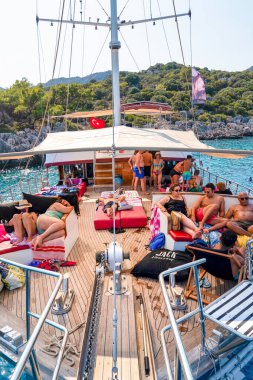 Antalya, Türkiye - 7 Ağustos 2024: Turistlerin Kas 'tan kalkan ve Kekova' ya giden turist teknesinde eğlendikleri dikey görünüm