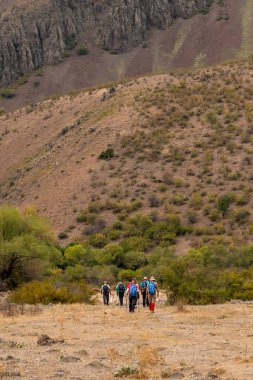 Yürüyüşçülerin yürüyüp zirveye gidişlerinin arka görüntüsü.
