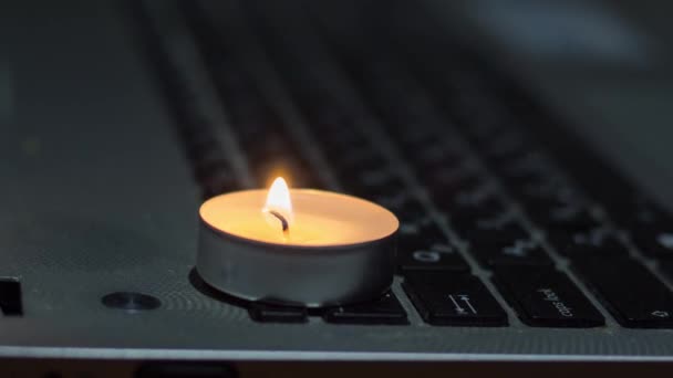 ノートパソコンのキーボードでキャンドル ウクライナでの戦争による停電 — ストック動画