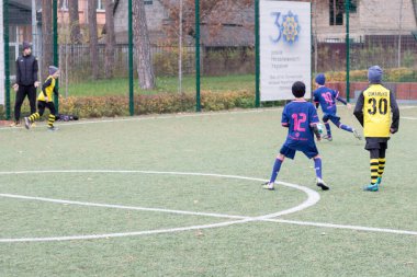 Çocuklar savaş sırasında Ukrayna 'daki futbol sahasında futbol oynuyor.