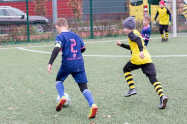 Çocuklar savaş sırasında Ukrayna 'daki futbol sahasında futbol oynuyor.