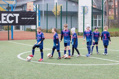 Çocuklar savaş sırasında Ukrayna 'daki futbol sahasında futbol oynuyor.