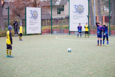 Çocuklar savaş sırasında Ukrayna 'daki futbol sahasında futbol oynuyor.