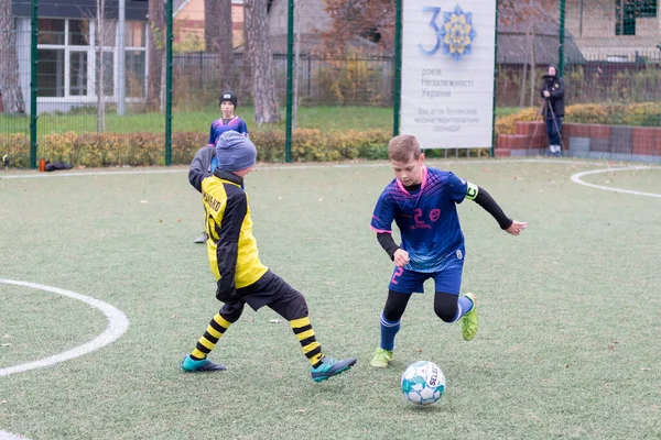 Çocuklar savaş sırasında Ukrayna 'daki futbol sahasında futbol oynuyor.