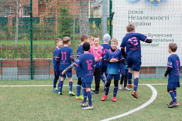 Çocuklar savaş sırasında Ukrayna 'daki futbol sahasında futbol oynuyor.