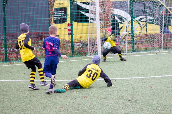 Çocuklar savaş sırasında Ukrayna 'daki futbol sahasında futbol oynuyor.