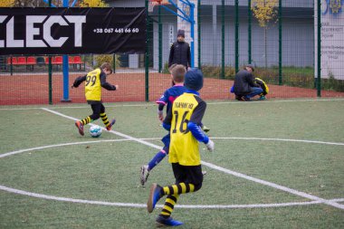 Çocuklar savaş sırasında Ukrayna 'daki futbol sahasında futbol oynuyor.