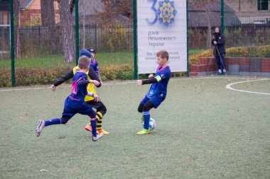 Çocuklar savaş sırasında Ukrayna 'daki futbol sahasında futbol oynuyor.