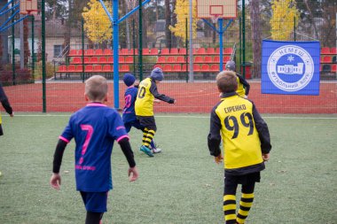 Çocuklar savaş sırasında Ukrayna 'daki futbol sahasında futbol oynuyor.