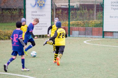 Çocuklar savaş sırasında Ukrayna 'daki futbol sahasında futbol oynuyor.