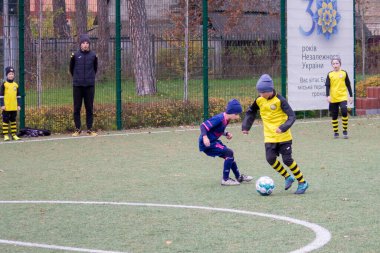 Çocuklar savaş sırasında Ukrayna 'daki futbol sahasında futbol oynuyor.