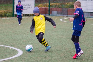 Çocuklar savaş sırasında Ukrayna 'daki futbol sahasında futbol oynuyor.