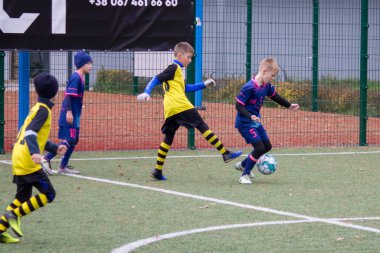 Çocuklar savaş sırasında Ukrayna 'daki futbol sahasında futbol oynuyor.