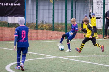 Çocuklar savaş sırasında Ukrayna 'daki futbol sahasında futbol oynuyor.