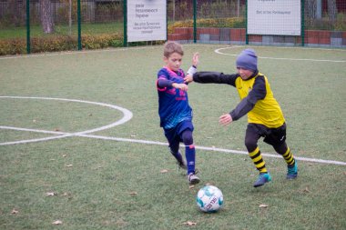 Çocuklar savaş sırasında Ukrayna 'daki futbol sahasında futbol oynuyor.