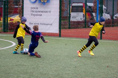 Çocuklar savaş sırasında Ukrayna 'daki futbol sahasında futbol oynuyor.