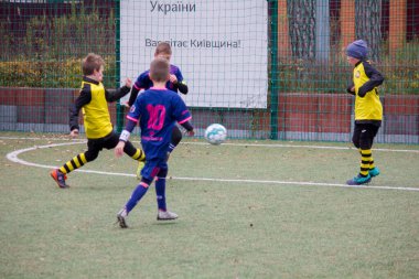 Çocuklar savaş sırasında Ukrayna 'daki futbol sahasında futbol oynuyor.