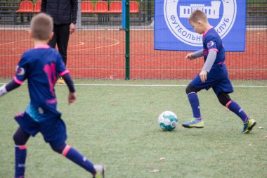 Çocuklar savaş sırasında Ukrayna 'daki futbol sahasında futbol oynuyor.