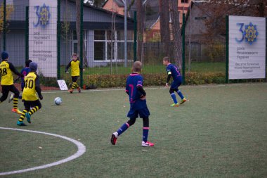 Çocuklar savaş sırasında Ukrayna 'daki futbol sahasında futbol oynuyor.