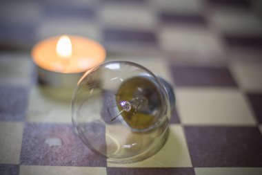 Satranç tahtasında yanan mum ve lamba. Ukrayna 'daki savaştan dolayı karartma