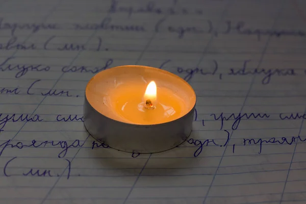 学校のノートに燃えるろうそく ウクライナでの戦争による停電 — ストック写真