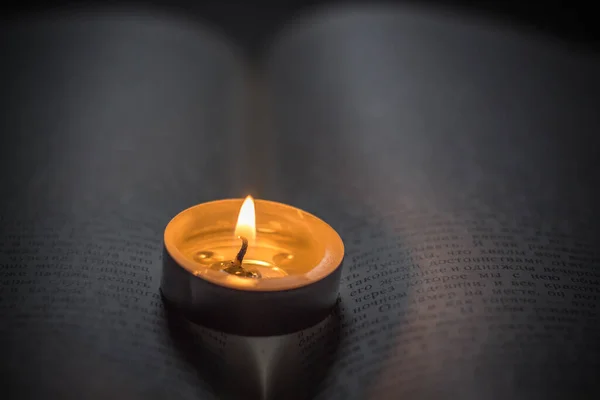 在书上点着蜡烛乌克兰战争造成的停电 — 图库照片