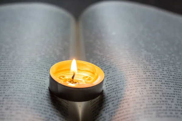 本の上でろうそくを燃やす ウクライナでの戦争による停電 — ストック写真