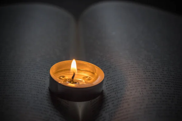 在书上点着蜡烛乌克兰战争造成的停电 — 图库照片