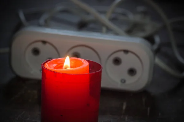 電気延長コードの近くの燃えるろうそく ウクライナでの戦争による停電 — ストック写真