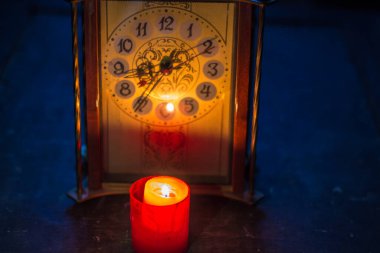 Saatin yanında yanan mum. Savaş nedeniyle Ukrayna 'da uzun süre elektrik kesintisi