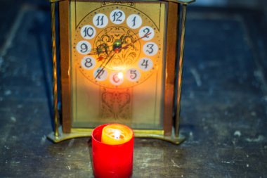 Saatin yanında yanan mum. Savaş nedeniyle Ukrayna 'da uzun süre elektrik kesintisi