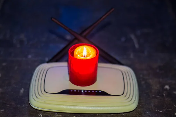 Yönlendiricinin üzerinde yanan mum. Ukrayna 'da savaş nedeniyle kesintiler