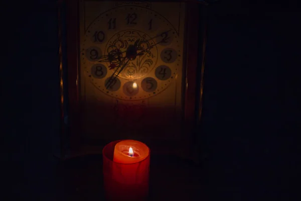時計の近くでろうそくを燃やす 戦争のためにウクライナの長い停電 — ストック写真