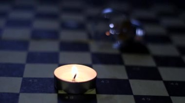 Satranç tahtasında yanan mum ve lamba. Ukrayna 'daki savaştan dolayı karartma