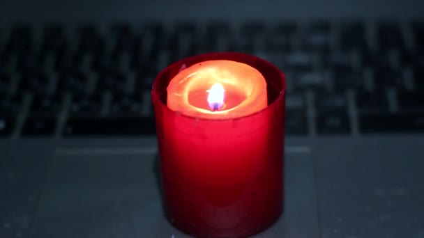ノートパソコンのキーボードでキャンドル ウクライナでの戦争による停電 — ストック動画