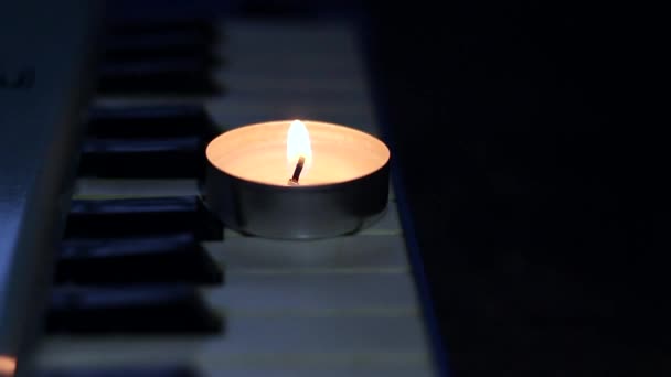 靠近被单的合成器钥匙上燃着的蜡烛 上面附有笔记 乌克兰因战争而停电 — 图库视频影像